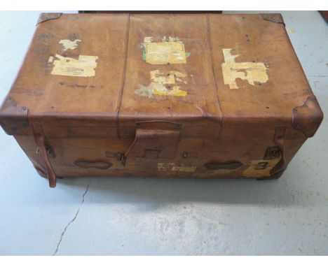 A vintage leather trunk with a brass lock, 36cm tall x 91cm x 52cm, in polished usable condition 