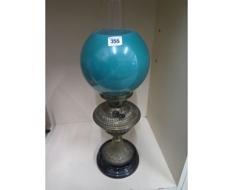 A brass oil lamp with a green glass shade, with nicks, generally good, 55cm tall including chimney