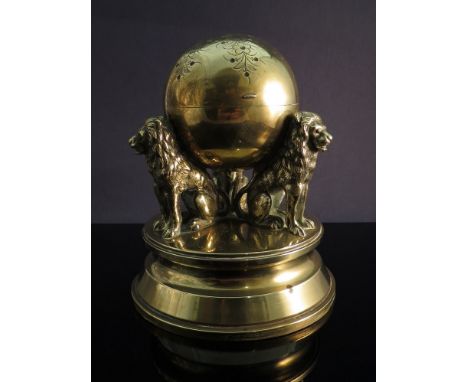 A Victorian brass ink stand with ceramic insert in the form of three lions carrying an engraved globe, 12cm x 13cm