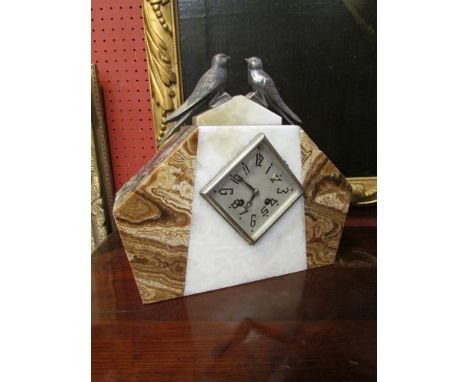 A French Art Deco mantel clock surmounted by birds in onyx and marble case with lozenge silvered Arabic dial, 31cm tall
