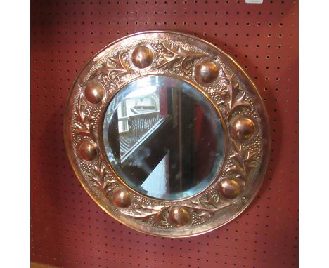 A Keswick school of Industrial Art, copper mirror with bevelled glass, rounded and leaf border 41.5cm diameter 