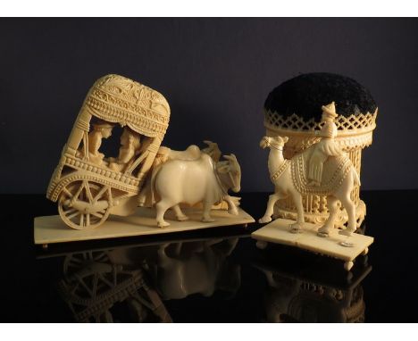 An early 20th Century ivory pin cushion, an ivory camel with rider and an ivory oxen a/f