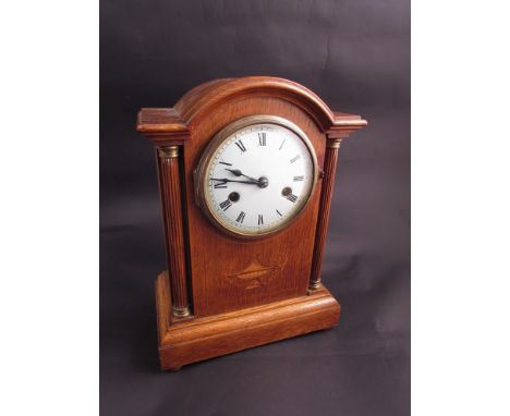 A 19th Century oak mantel clock, domed top, with Roman numeral dial column supports, with inlay and key 