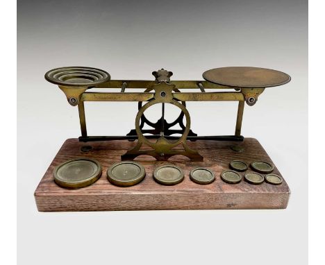 A set of late Victorian Sampson Mordan &amp; Co brass and oak postal scales, the base set with nine brass weights, width 25.5