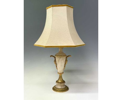 An ornate alabaster table lamp, early 20th century, with gilt metal mask handles and mounts, height 39cm.