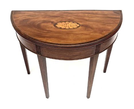 A George III mahogany demi lune fold over card table, the top with a shell inlaid oval panel and rosewood crossbanding, on sq