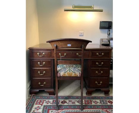 An Edwardian mahogany twin pedestal writing desk, with tooled leather skiver, and fitted with an arrangement of nine drawers,