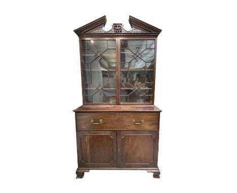 A George III mahogany secretaire bookcase, in the style of Thomas Chippendale, the fine fretwork cornice above a pair of astr