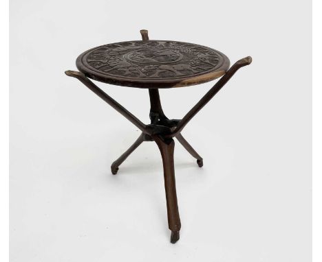 An African carved hardwood table, raised on a folding tripod base, diameter 44cm.