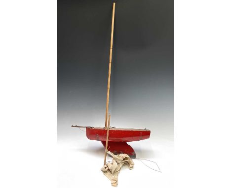 A vintage red painted pond yacht of primitive form, with weighted keel. Overall length 52cm.