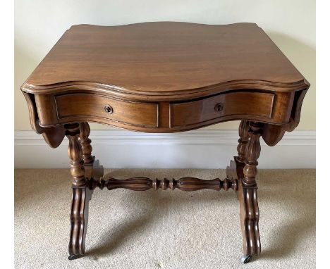 A French walnut serpentine shaped sofa table, circa 1880, fitted with two drawers and raised on turned and fluted legs and st