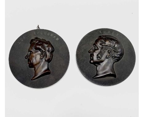 A pair of 19th century bois durci circular portrait plaques, relief moulded and titled for Auber and Lord Brougham, diameter 