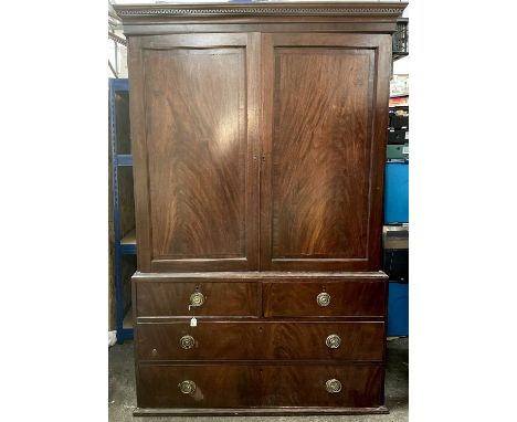 A George III mahogany linen press, the dentil cornice above a pair of cupboard doors enclosing trays, the lower part with two