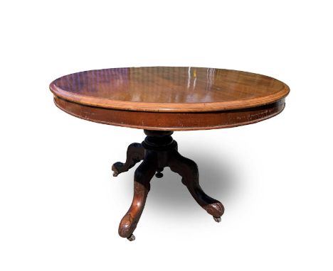 A Victorian mahogany tilt top oval table, raised on a turned column and leaf carved quadruped base. Height 76cm, width 132cm,