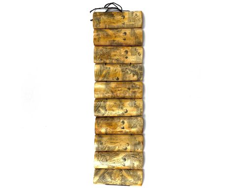 A Chinese bone erotic panel, 20th century. Comprising of ten rectangular sections, 11 x 39cm.
