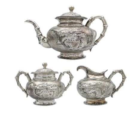 A Chinese silver three-piece tea service, late 19th century.  Makers marks for Woshing, Shanghai, comprising a teapot, milk j