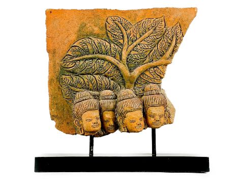 A Khmer pottery relief panel, Cambodian, 20th century. Depicting four Buddhist heads beneath a tree canopy, height 34cm, widt