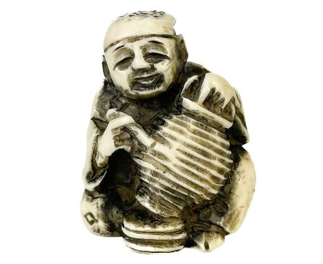 A Japanese bone netsuke. Carved as a seated gentleman painting a vase, signed, height 4cm.