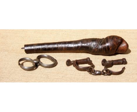 A POACHER’S THROWING STICK AND TWO PAIRS OF HANDCUFFS.  Age of stick indeterminate. Exceptionally scarce. Top-weighted as it 