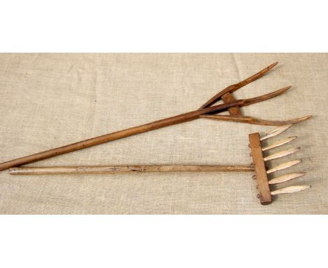 A WOODEN SWATHE TURNING FORK AND A WOODEN GATHERING RAKE. Both 19th century.