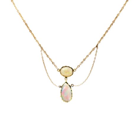 An Edwardian opal and yellow metal pendant, circa 1905, oval opal cabochon and pendeloque opal suspended from one another and