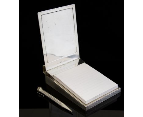 Asprey & Co, a George V silver note pad with a spring lid and weighted base, engine turned decoration, including an 'Evershar
