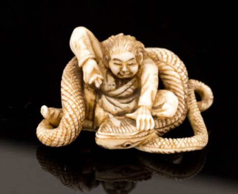 An Oriental ivory netsuke, carved as a man slaying a snake, signed, width 4cm (s.d)