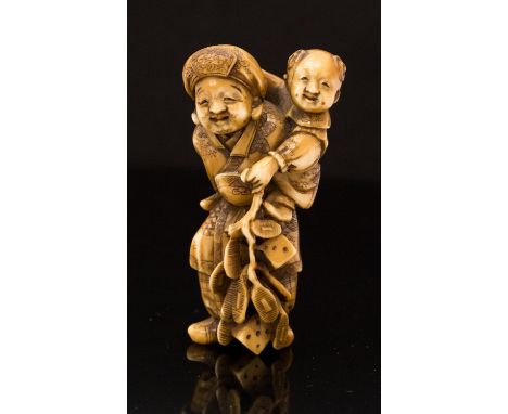 An ivory netsuke of an elderly man holding an infant, height 7cm