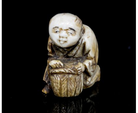 An oriental ivory netsuke, carved as a boy with a basket, height 3cm
