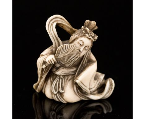 An Oriental ivory netsuke, carved as a reclining Geisha with a fan, height 3cm