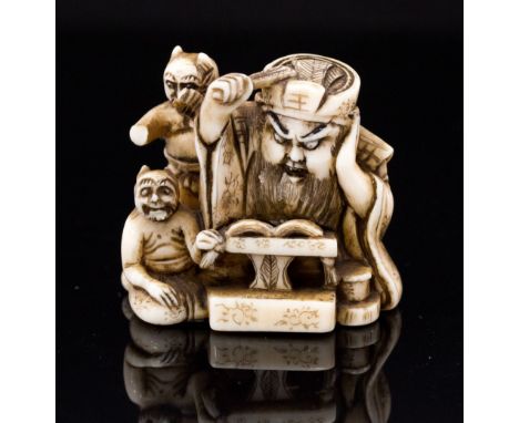 An Oriental ivory netsuke, carved as a bearded man and two demons, width 3.5cm