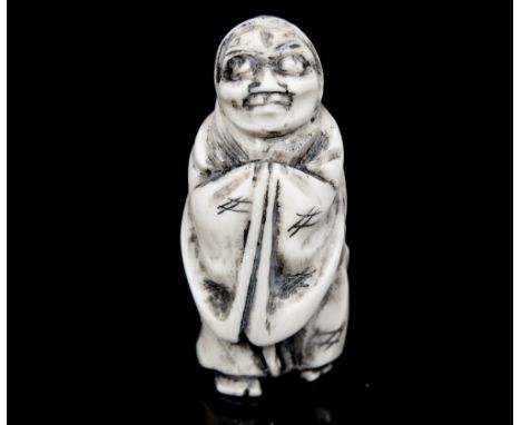 An Oriental bone/ivory netsuke, carved as a standing robed elderly lady, height 4cm