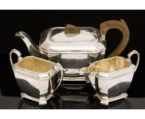 A George VI Scottish silver three piece tea service in an Art Deco style, the teapot having a wood handle and finial, retaile