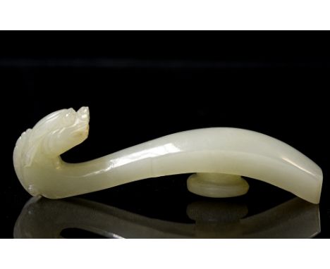 An antique Chinese pale jade belt hook, the finial carved as a dragon head, 7.5cm long