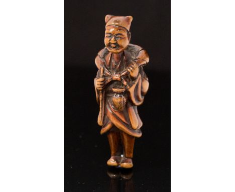 An Oriental carved treen netsuke, carved as a standing man with backpack, height 7cm