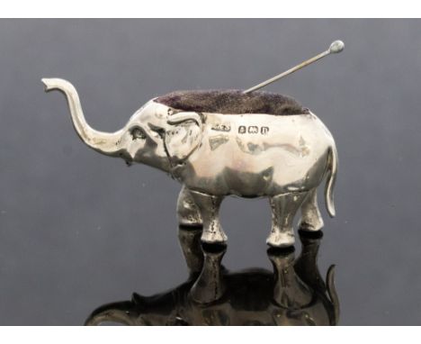 A George V silver Elephant pin cushion with original cushion and raised trunk, maker Levi and Salaman (part rubbed) hallmark 