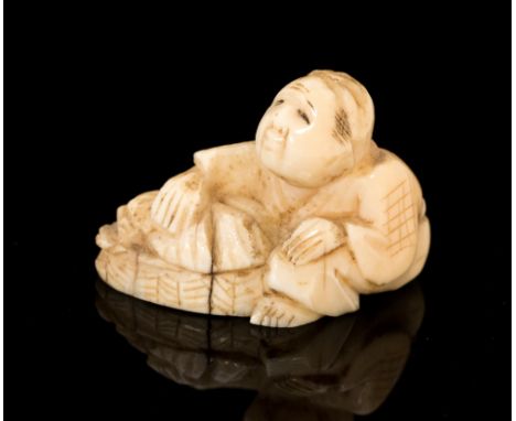 An Oriental ivory netsuke, carved as a crouching man, signed, width 3cm