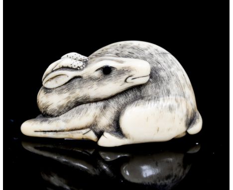 An Oriental ivory netsuke, carved as a recumbent deer, width 4.5cm