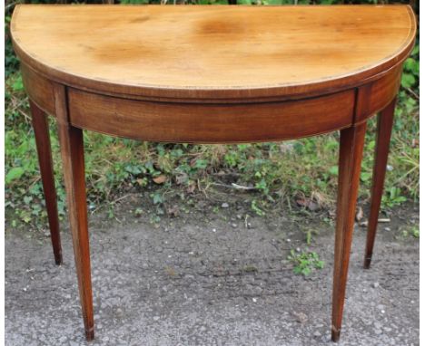 A George III mahogany demilune card table, circa 1800, raised on square tapered legs, 73cm high, 91cm wide and 46cm deep