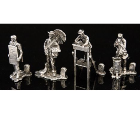 A set of four modern silver figurine menu holders, each with a split tombstone as the holder, the figurines depicting a bill 