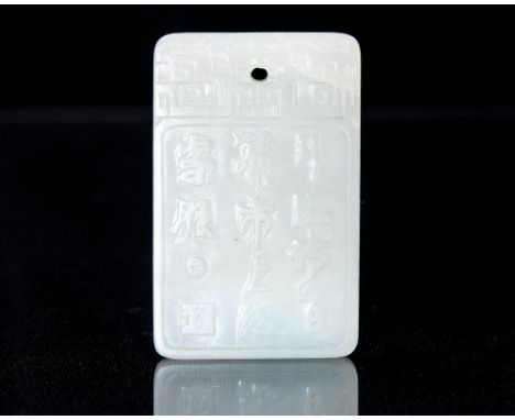 A Chinese carved jade slab pendant, engraved with a verse to one side, the other with a man in a garden, 4.6cm x 2.8cm