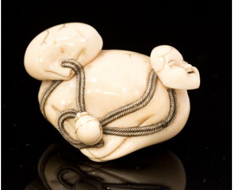 An oriental ivory netsuke, in the form of two shells and a mask, signed, width 4.5cm