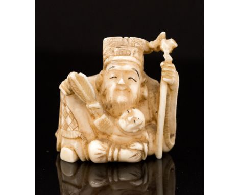 An Oriental ivory netsuke, carved as bearded gent with a staff and an infant with a fan, signed, height 4cm
