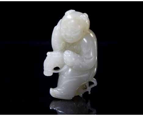 A Chinese carved jade pendant modelled as a boy on a hobby horse, 5.5cm long