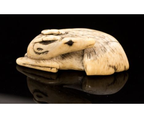 An Oriental ivory netsuke of a recumbent deer, width 5cm