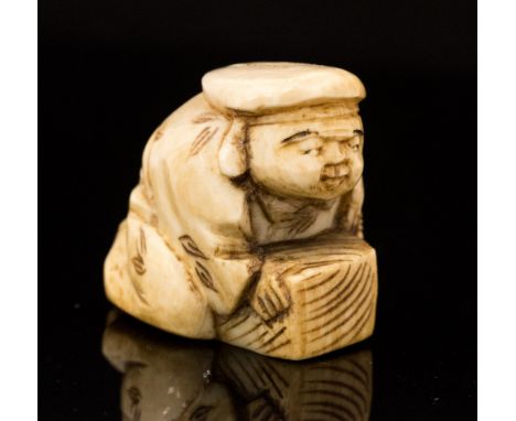 An Oriental ivory netsuke, carved as Hotei crouching with a box, height 3cm