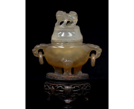 A Chinese amber jade or agate censer on hardwood stand, ring handles, the lid with a Shi finial, 13cm high including stand