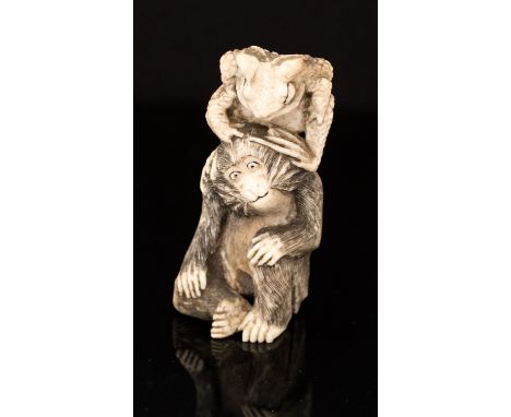 An Oriental ivory netsuke, carved as a toad upon a monkey, height 6.5cm