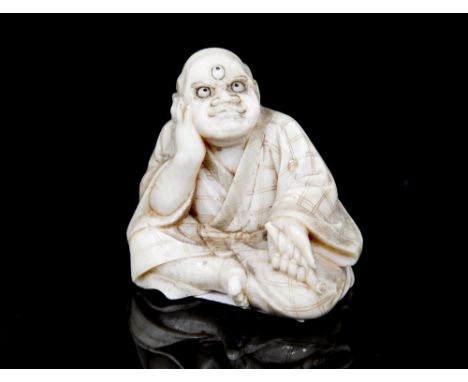 An Oriental ivory netsuke, carved as a seated disgruntled man, inset red seal signature, height 3cm