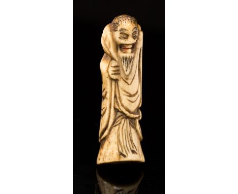 An Oriental bone netsuke, carved as a bearded sage, height 5cm